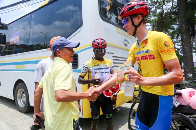 HLV Đỗ Thành Đạt của TP HCM chúc mừng hai tay đua Yarash (Áo Vàng) và Moise Áo Đỏ - Vua leo núi, cuộc đua xe đạp xuyên Việt tranh Cup Truyền hình HTV 2026, trưa 20/4. Ảnh: Phạm Huy