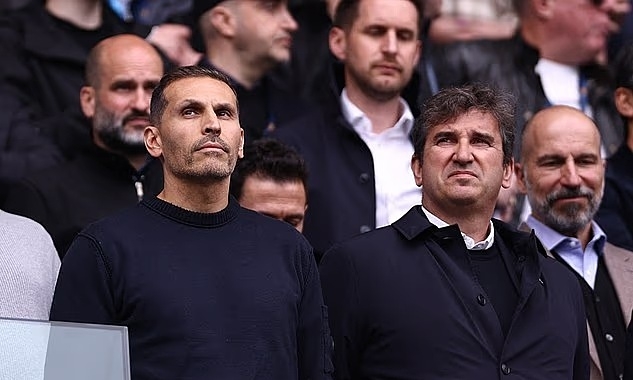 Chủ tịch Khaldoon Al Mubarak (trái, hàng đầu) đứng cạnh Giám đốc điều hành Ferran Soriano trước trận Man City gặp Arsenal trên sân Etihad, thành phố Manchester, vòng 33 Ngoại hạng Anh ngày 19/4/2026. Ảnh: Reuters