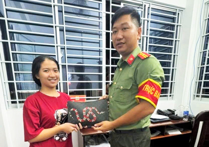 Em Trần Thanh Ngọc bàn giao lại túi xách có 200 triệu đồng cho Công an phường Long An hai hôm trước. Ảnh: Nam An