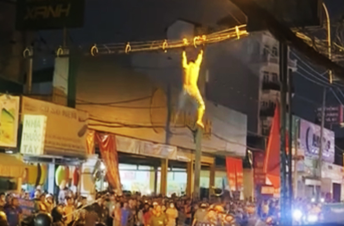 Nam thanh niên đu dây cáp trước khi rơi xuống. Ảnh: Người dân cung cấp