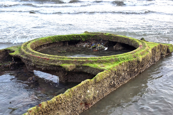 Vật thể nghi xác xe tăng phát lộ khi thủy triều rút. Ảnh: Quốc Cường