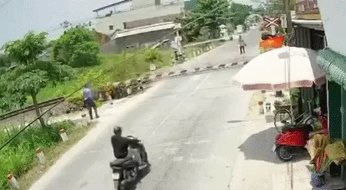 Lái xe máy tông gãy gác chắn khi tàu sắp đến