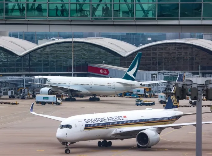 Máy bay của Singapore Airlines di chuyển trên đường lăn, phía sau là phi cơ của Cathay Pacific tại sân bay quốc tế Hong Kong. Ảnh: Jelly Tse